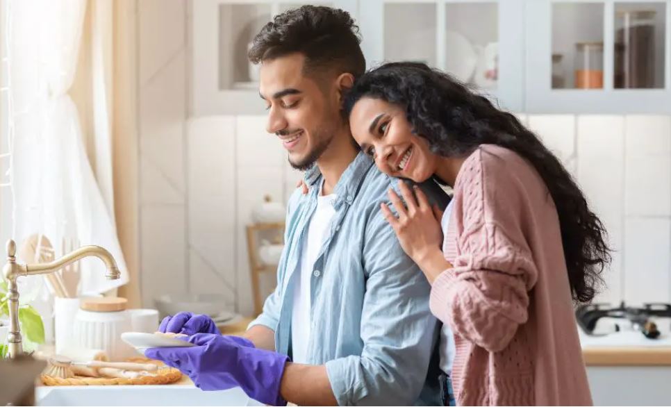 A man wahsing dishes as an act of service one of the love languages
